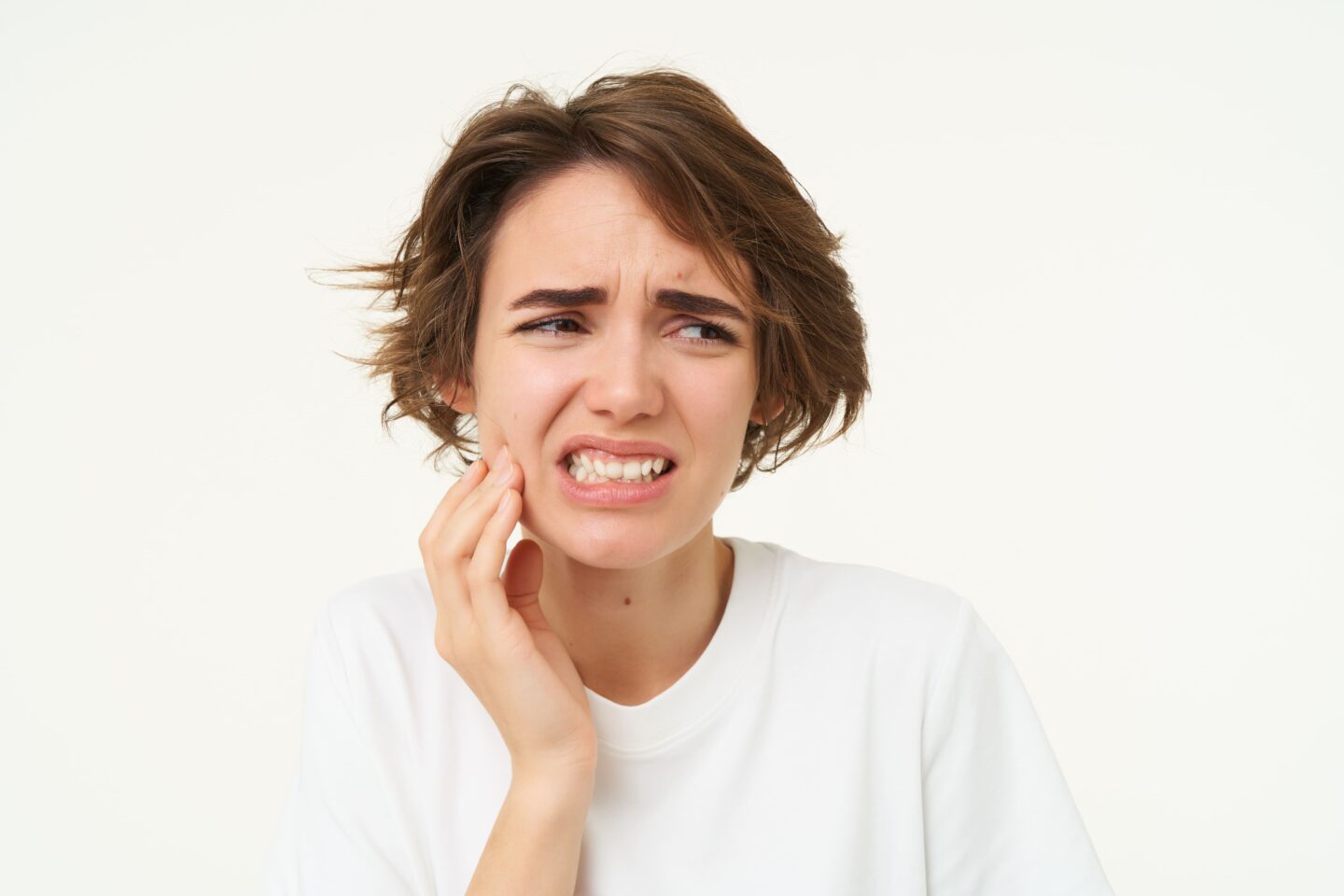 imagen de una chica aprenando los dientes con dolor de mandibula